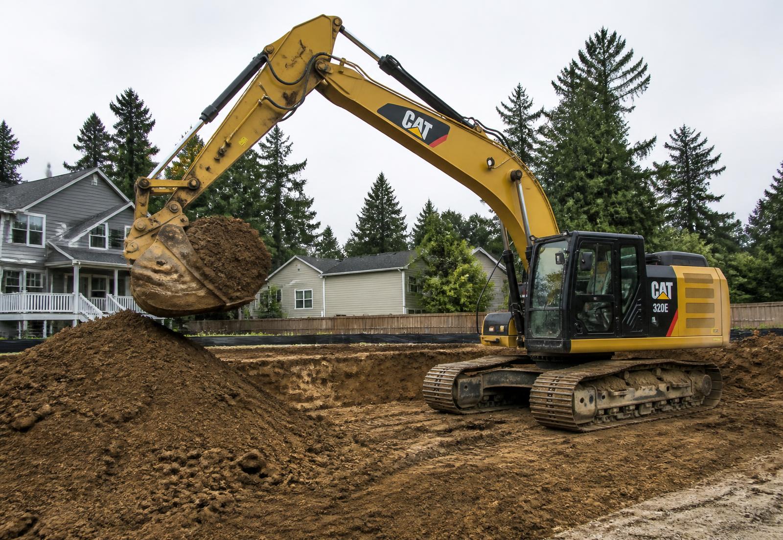 Tracked excavator moving soil on a residential site preparation job
